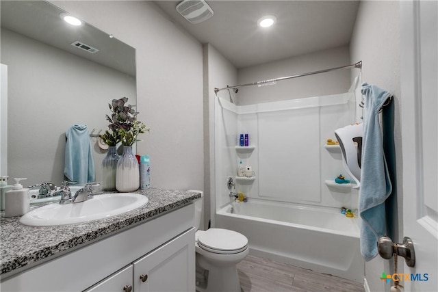 full bathroom featuring shower / washtub combination, toilet, hardwood / wood-style floors, and vanity