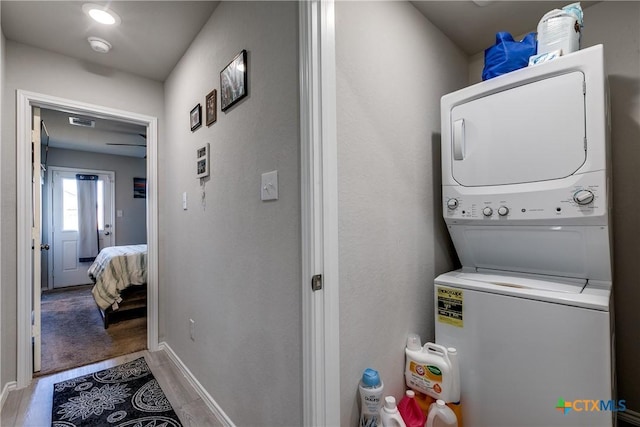 clothes washing area with stacked washer / drying machine and light hardwood / wood-style floors