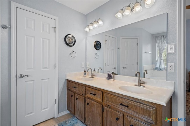 bathroom with double vanity, tile patterned floors, and a sink