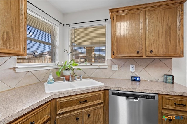 kitchen featuring dishwasher, decorative backsplash, a wealth of natural light, and a sink