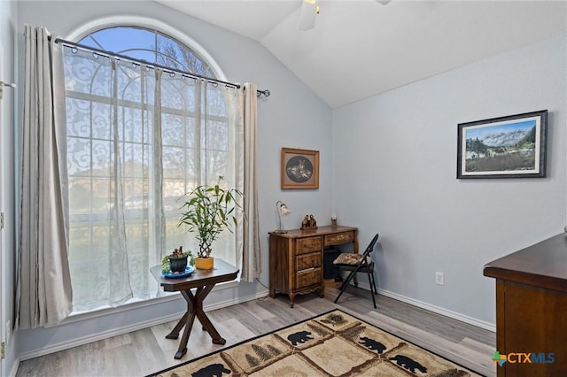 home office with vaulted ceiling, wood finished floors, baseboards, and ceiling fan