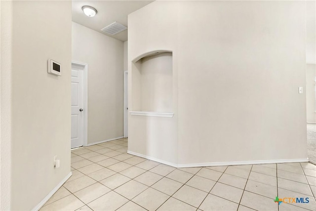 unfurnished room with light tile patterned floors, visible vents, and baseboards