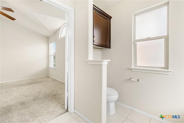 bathroom with tile patterned flooring, toilet, lofted ceiling, and ceiling fan