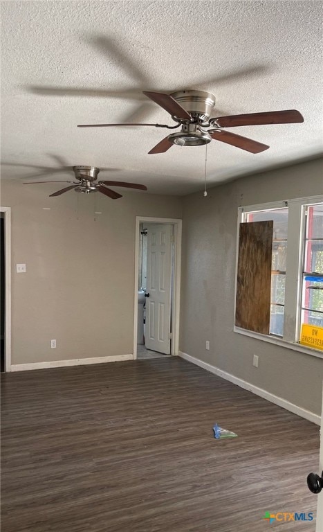 empty room featuring dark hardwood / wood-style flooring, a textured ceiling, and ceiling fan