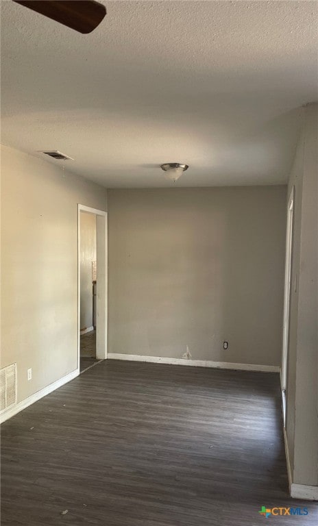 empty room with dark hardwood / wood-style floors, ceiling fan, and a textured ceiling