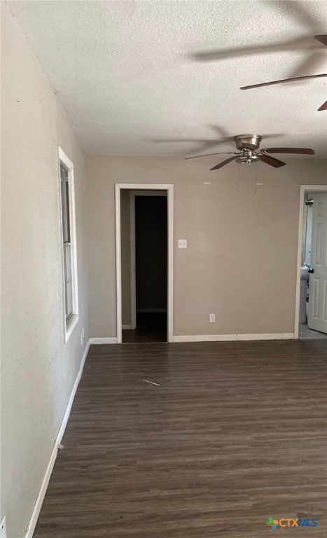 unfurnished room with ceiling fan, dark wood-type flooring, and a textured ceiling