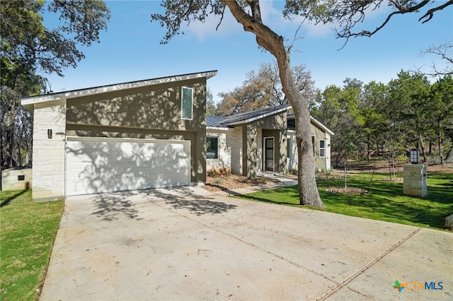 3006 Dew Drop, Horseshoe Bay, TX 78657 - mid-century inspired home with concrete driveway, a front yard, metal roof, a garage, and stone siding