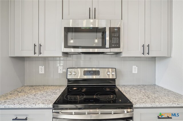 3006 Dew Drop, Horseshoe Bay, TX 78657 - kitchen with stainless steel appliances, backsplash, white cabinets, and light stone counters