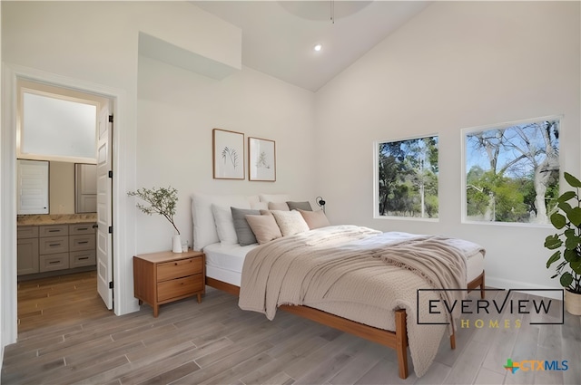 3006 Dew Drop, Horseshoe Bay, TX 78657 - bedroom featuring high vaulted ceiling, light wood-style flooring, baseboards, ensuite bath, and recessed lighting
