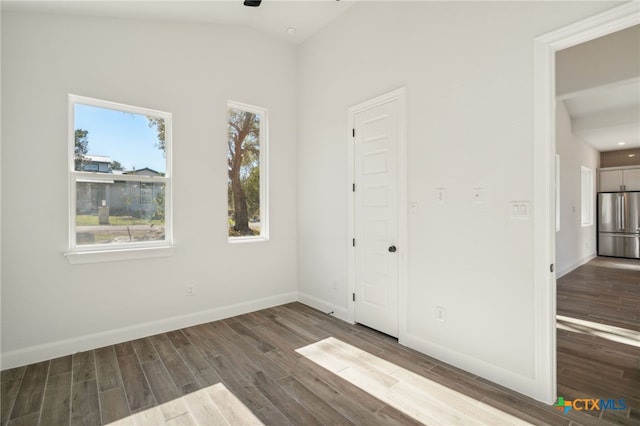 3006 Dew Drop, Horseshoe Bay, TX 78657 - unfurnished bedroom with stainless steel fridge, wood finished floors, baseboards, lofted ceiling, and recessed lighting