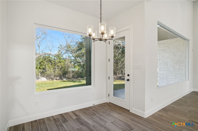 3006 Dew Drop, Horseshoe Bay, TX 78657 - unfurnished dining area featuring a chandelier, dark wood finished floors, and baseboards