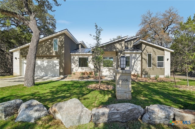 3006 Dew Drop, Horseshoe Bay, TX 78657 - mid-century modern home featuring driveway, a front yard, metal roof, stucco siding, and a standing seam roof
