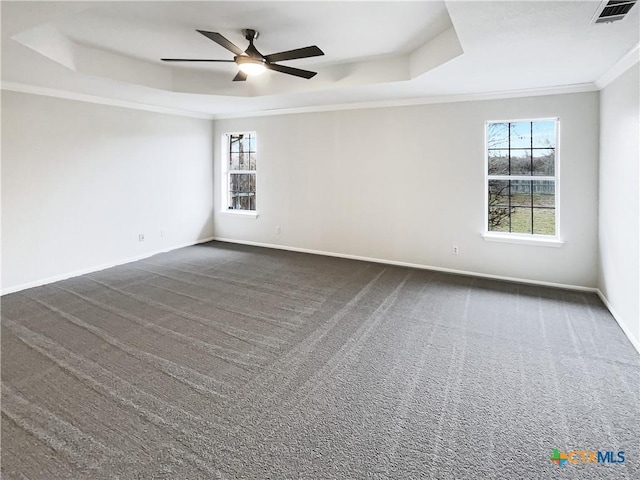 carpeted empty room featuring a raised ceiling, ceiling fan, and ornamental molding