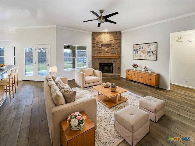 living room featuring ceiling fan, dark hardwood / wood-style flooring, crown molding, and a brick fireplace