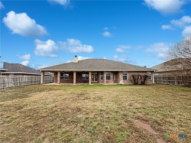 rear view of house featuring a lawn and a patio