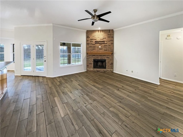 unfurnished living room with dark hardwood / wood-style flooring, ceiling fan, a fireplace, and ornamental molding