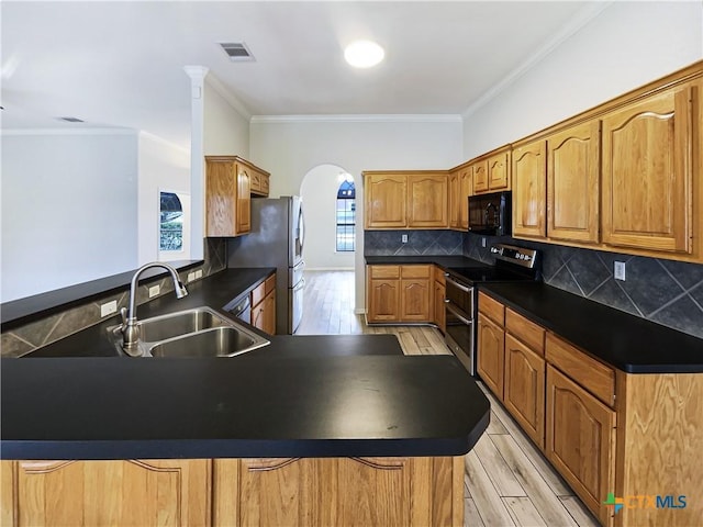 kitchen with kitchen peninsula, decorative backsplash, stainless steel appliances, and sink