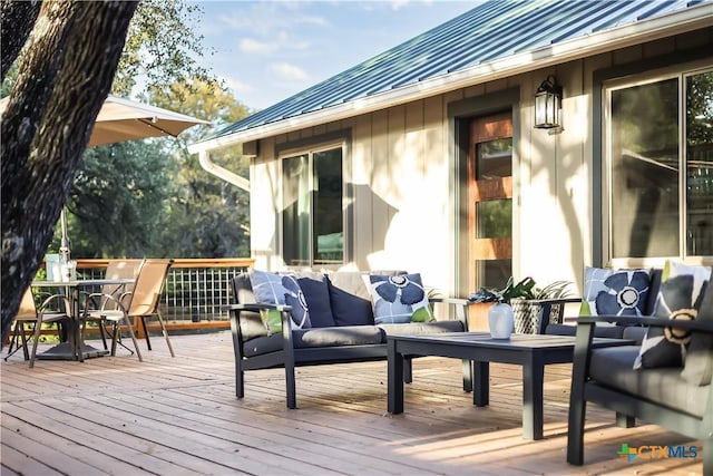 wooden terrace with an outdoor living space