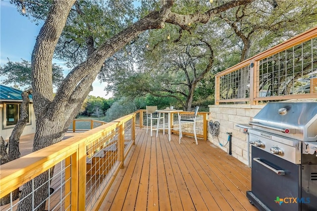 wooden deck featuring a grill