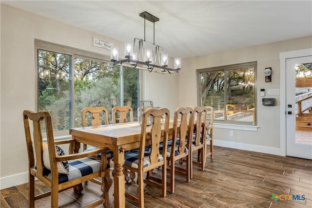 dining space featuring dark wood-type flooring and a chandelier