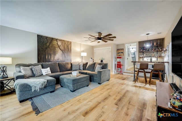 living room featuring ceiling fan and light wood-type flooring