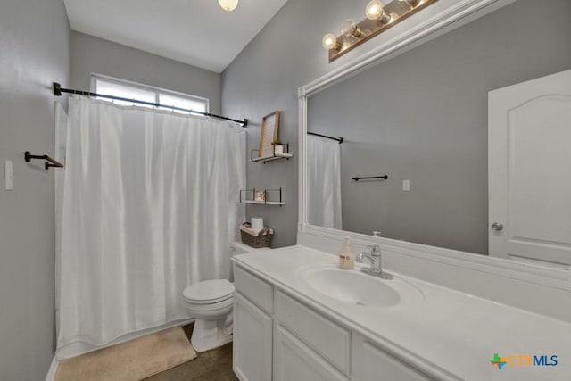 bathroom featuring vanity, a shower with shower curtain, and toilet