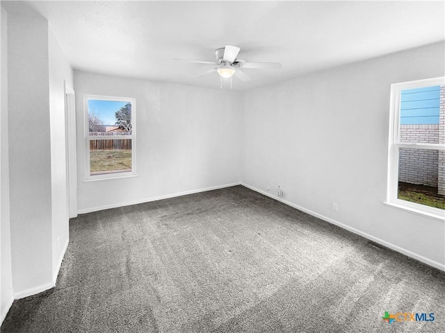 carpeted spare room with ceiling fan and a wealth of natural light