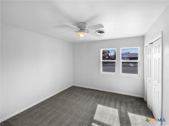 unfurnished bedroom featuring ceiling fan, a closet, and dark colored carpet