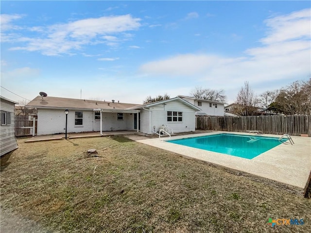 rear view of house featuring a patio, a yard, and a fenced in pool