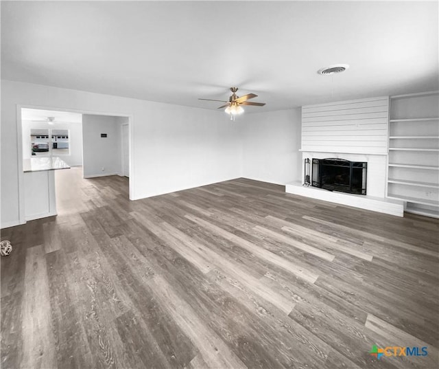 unfurnished living room with ceiling fan, dark hardwood / wood-style flooring, and a fireplace