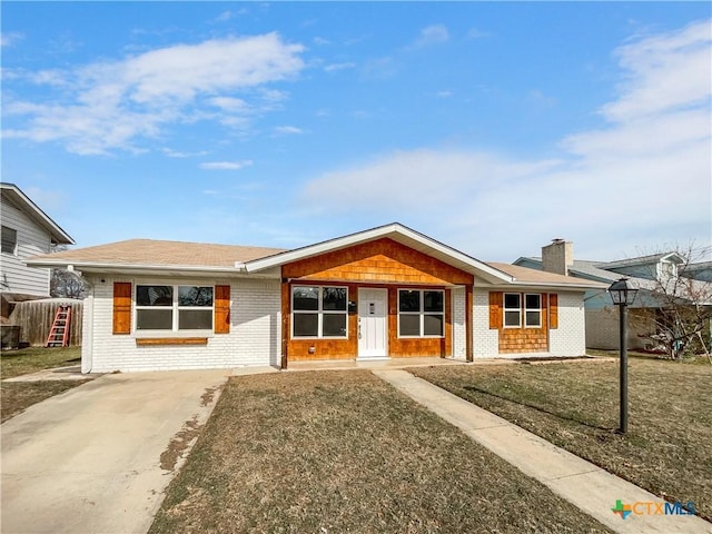 ranch-style home featuring covered porch and a front lawn