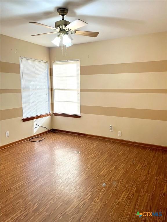 spare room featuring hardwood / wood-style floors and ceiling fan