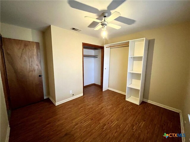 unfurnished bedroom featuring ceiling fan, dark wood-type flooring, and a closet