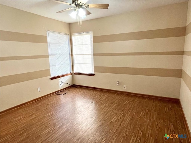 unfurnished room with dark hardwood / wood-style flooring and ceiling fan