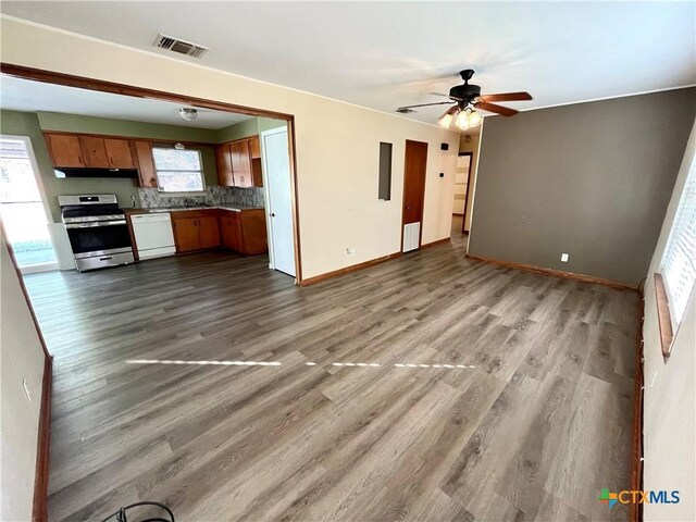 unfurnished living room featuring ceiling fan, plenty of natural light, and wood-type flooring