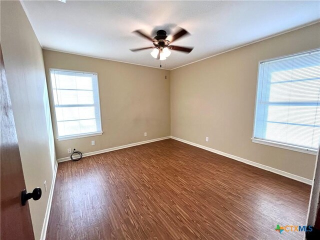 empty room featuring dark hardwood / wood-style flooring and ceiling fan