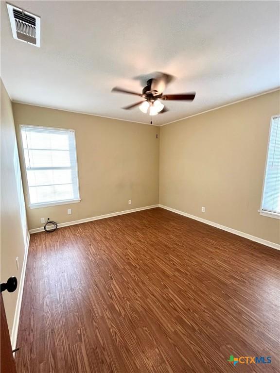 empty room with ceiling fan and dark wood-type flooring