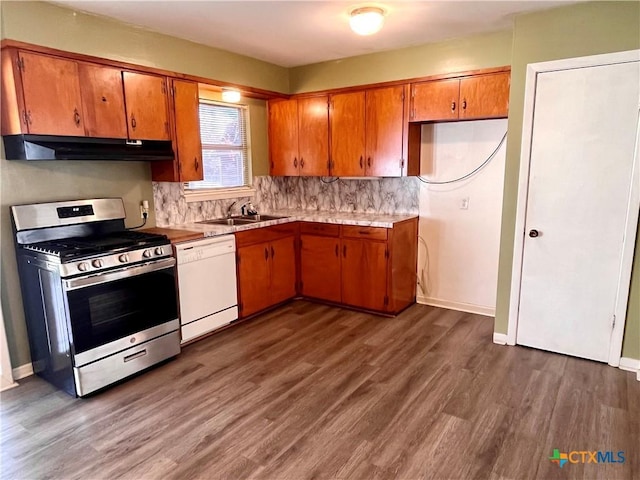 kitchen with dark hardwood / wood-style flooring, white dishwasher, stainless steel range with gas cooktop, and sink