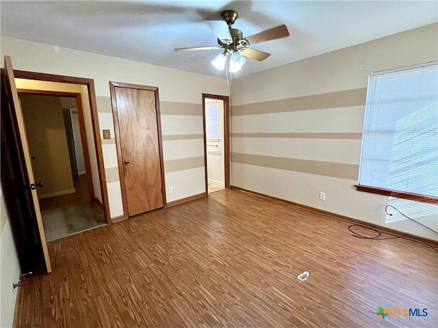 unfurnished bedroom with ceiling fan and hardwood / wood-style flooring