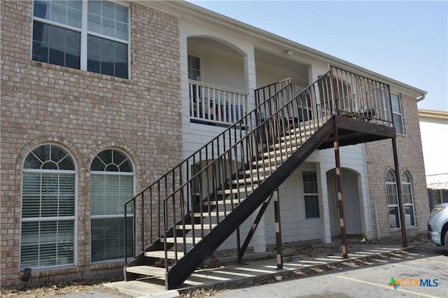 view of home's exterior with stairway and brick siding