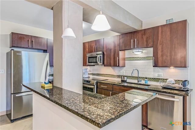 kitchen with sink, pendant lighting, appliances with stainless steel finishes, and tasteful backsplash