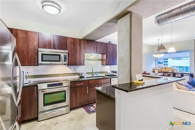 kitchen with sink, appliances with stainless steel finishes, dark stone counters, decorative light fixtures, and backsplash