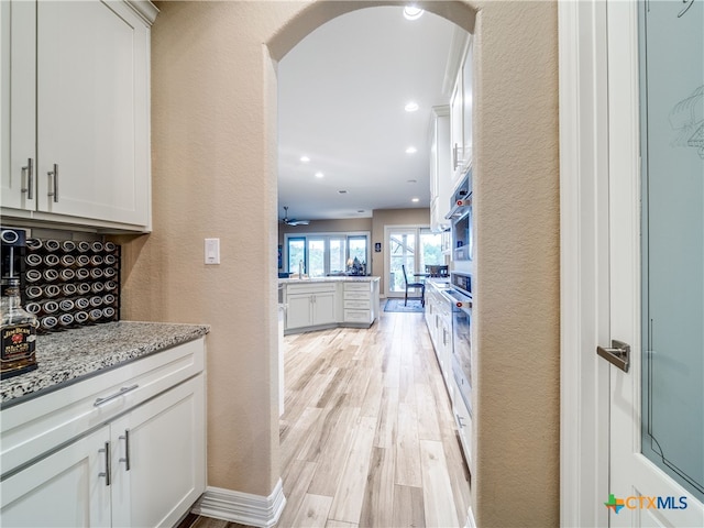 779 Stirrup Dr, Spring Branch, TX 78070 - bar area with a textured wall, light wood-style floors, arched walkways, recessed lighting, and a sink