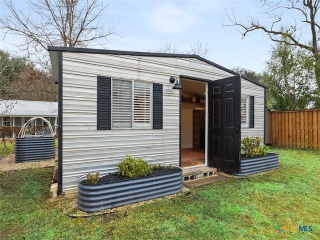 view of front of home featuring an outdoor structure and a front lawn