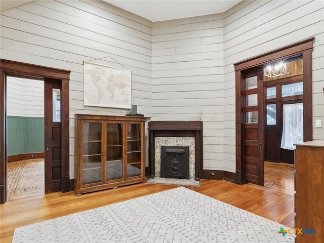 unfurnished living room featuring hardwood / wood-style flooring and wooden walls