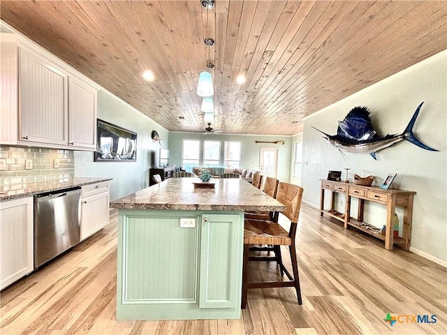 kitchen featuring backsplash, open floor plan, white cabinets, dishwasher, and a kitchen breakfast bar