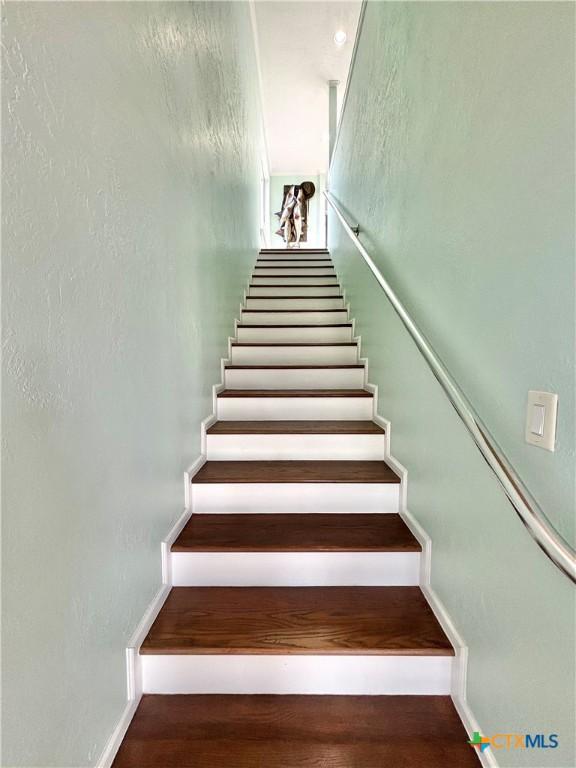 staircase with wood finished floors