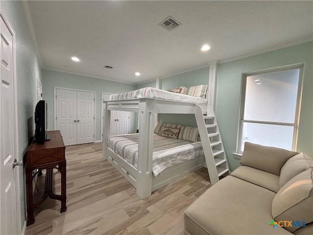 bedroom with light wood finished floors, recessed lighting, visible vents, and ornamental molding