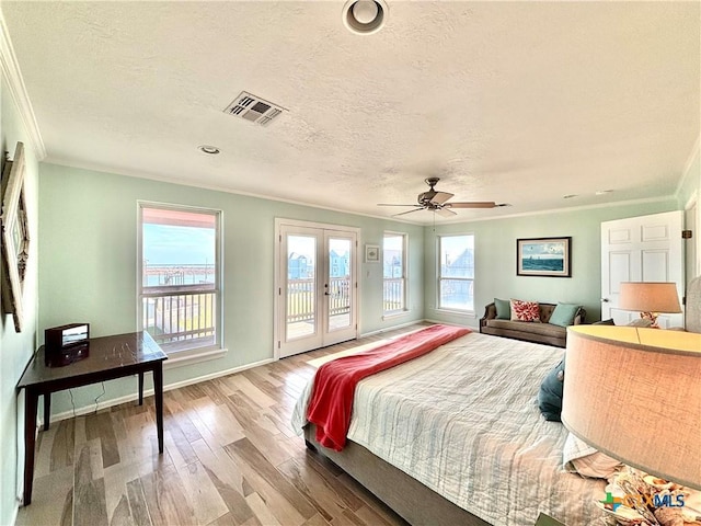 bedroom with access to exterior, multiple windows, visible vents, and wood finished floors