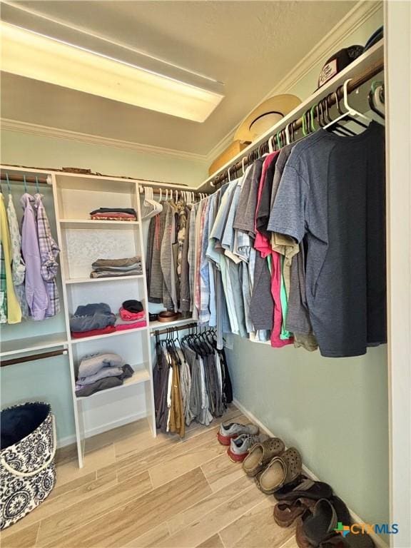 walk in closet with wood finished floors